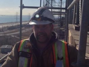 coating inspector standing on scaffold high above Toronto